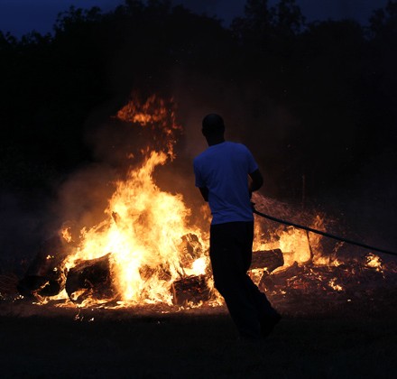 3blog-managing-fire man containing bonfire with garden hose